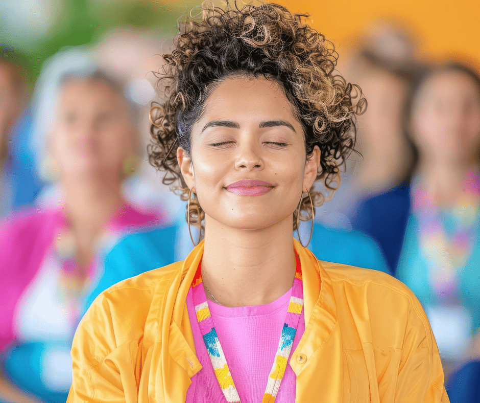 young women, eyes closed, wearing bright colors. Others behind her. Warm and inviting